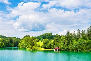 Rotes Holzhaus mit Badesteg am Forggensee bei Füssen