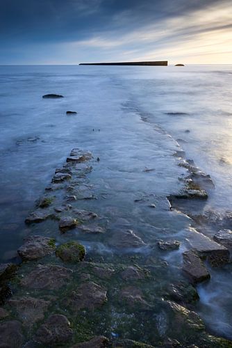 Rotsen in de voorgrond aan de Opaalkust in Frankrijk. van Rob Christiaans