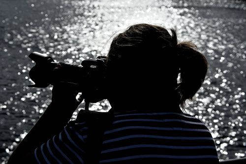 Silhouette van een fotograferende vrouw