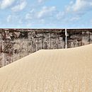 Zandverstuiving tegen een houten muur op het strand van Hans Kwaspen thumbnail