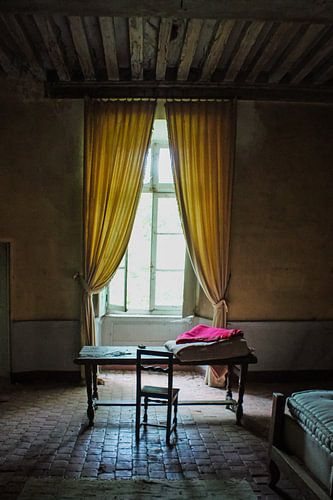 table in front of a window in an abandoned castle