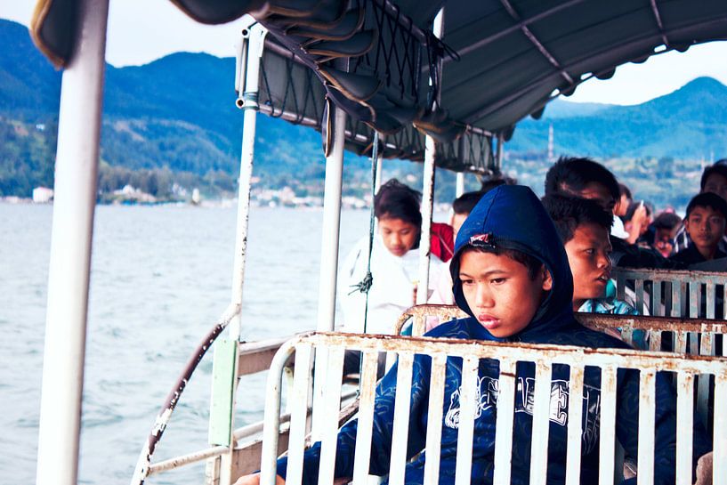 Indonesische schooljongen op de veerpont kijkt nadenkend in de verte by André van Bel