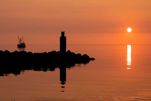 vissersboot en piertje bij zonsondergang