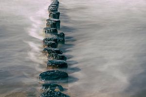 Strandpalen in de branding bij Cadzand-Bad. van Ellen Driesse