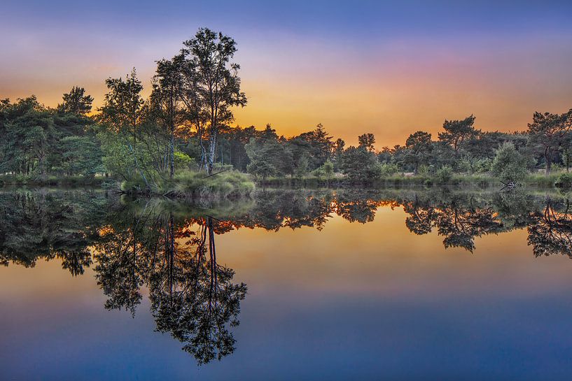 Tranquil lake at sunset with orange colored sky  by Tony Vingerhoets
