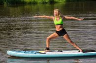 Jonge europese vrouw oefent yoga op SUP op water van Ben Schonewille thumbnail