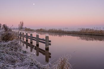 Winterse zonsopkomst bij het kanaal tijdens volle maan