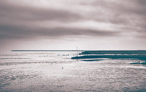 Strand van Cuxhaven aan de Duitse Noordzeekust.  Foto bij laag water met baken en golfbreker
