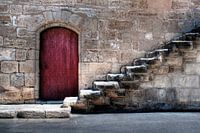 Old city wall with red door and stairs