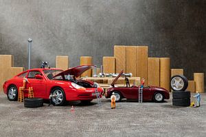 Little World Miniaturen arbeiten in einer Autowerkstatt, reparieren ein Auto, wechseln Reifen und üb