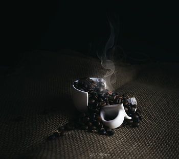 Broken Ceramic Cup with Steaming Roasted Coffee Beans on Burlap Surface