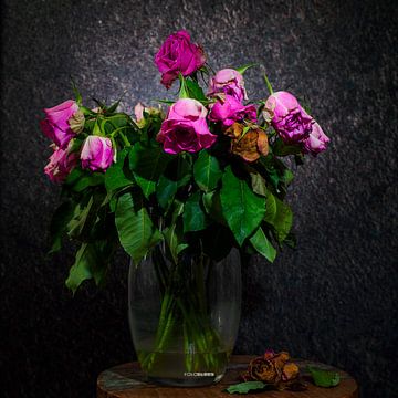 Uitgebloeide bos rozen in een vaas op een tafeltje van Ronald van de Steeg