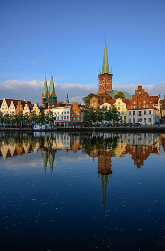 Stadtbild der historischen Altstadt von Lübeck in Deutschland mit Spiegelung in der Trave, beleuchte