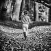 Zwart-wit foto van rennend meisje met vlechtjes op bos pad van Mayra Fotografie