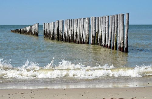 Strand mit Brandung und Pfählen im Meer