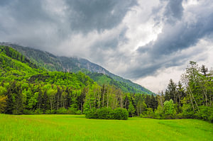 Alpenfrühlingsblick mit dramatischem Himmel im Hintergrund