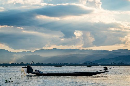 Fisherman picks up his nets at sunset on Lake Inle in Myanmar.