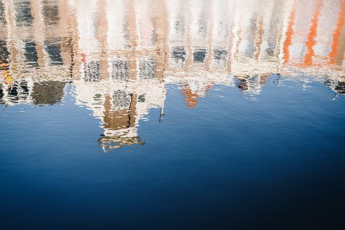 Reflectie van grachtenpanden op golven in het kanaal in Leiden, NL