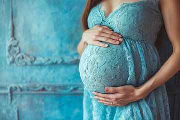 Eine schwangere Frau hält ihren Bauch und lehnt sich an eine blaue Hauswand von Animaflora PicsStock
