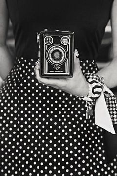 Woman in polkadot dress with vintage box camera