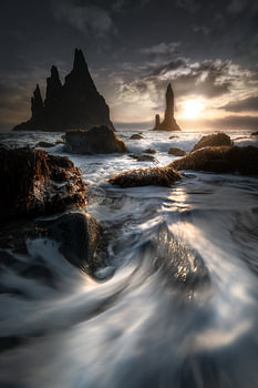 Paysage côtier islandais avec des roches de lave dans la lumière du soleil sur la plage de VIK.