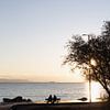 Couple at sunset by the sea in Greece by Jochem Oomen