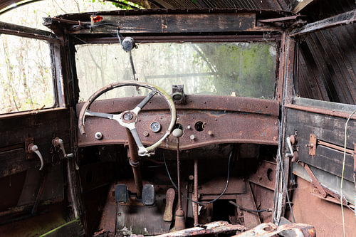 Rostiges Oldtimer-Cockpit mit großem Lenkrad
