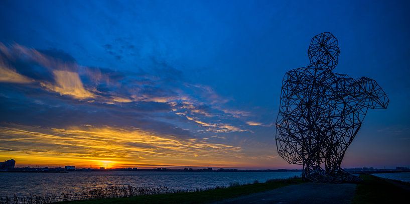 Setting sun at Lelystad near the Thinking Man by Peter de Jong