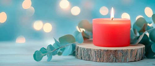 Rode kaars op houten schijf met eucalyptus