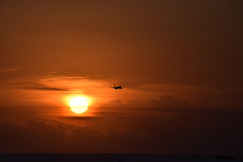 Vliegtuig tijdens een dieprode zonsondergang