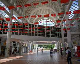 Eingang zum Kowloon Park mit festlich geschmückten Hongkonger und chinesischen Flaggen von Minimalistic Travel Photography by.Rieneke