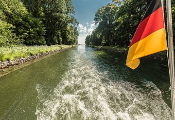 Aandrijfas van een boot op een kanaaldoorgang met zwaaiende Duitse vlag van Hans-Jürgen Janda