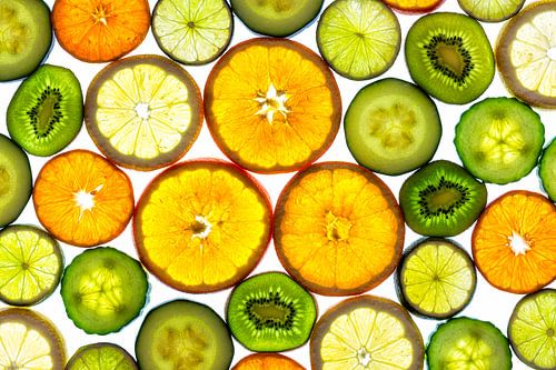 Collage van schijfjes fruit en groente met een witte achtergrond.