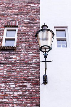 Old and new facade with cast iron wall lamp by Mayra Fotografie