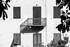 Balkon, dessen Schatten auf ein denkmalgeschütztes Gebäude in Lucca, Toskana, Italien, fällt. (Schwarz-Weiß) von André Blom Fotografie Utrecht