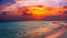 Zonsondergang op het strand met wolken