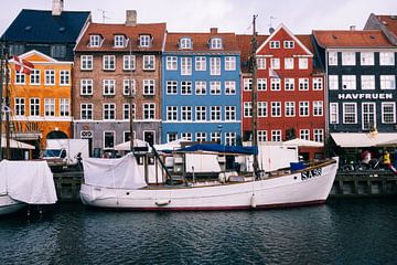 Sailboat with coloured Danish houses in the background in Nyhavn, Copenhagen (Denmark),