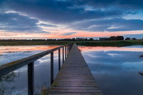 footbridge over water at sunrise.