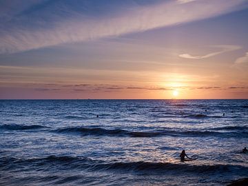 Surfer im Meer bei Sonnenuntergang. von Sjoerd van der Hucht