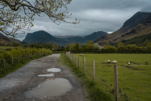 Eine unbefestigte Straße, die zum Lake Buttermere in Cumbria, England, führt.
