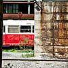 Old deserted train between buildings by Jan Brons