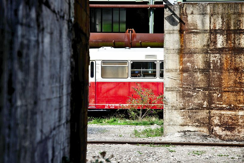 Oude verlaten trein tussen de gebouwen van Jan Brons