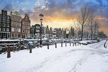Besneeuwd Amsterdam in de winter in Nederland bij zonsondergang van Eye on You