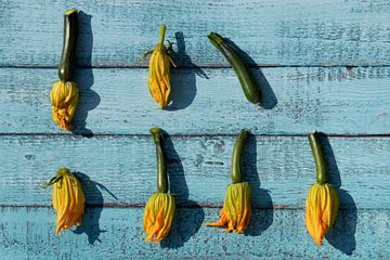 Courgette flowers on wooden boards by Ulrike Leone