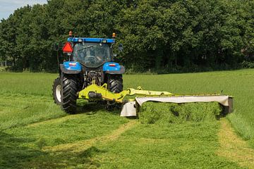 weiland maaien met blauwe tractor en maaimachine van Tonko Oosterink