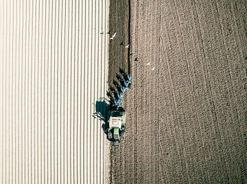 Tractor maakt de grond klaar voor het planten van gewassen van bovenaf gezien van Sjoerd van der Wal