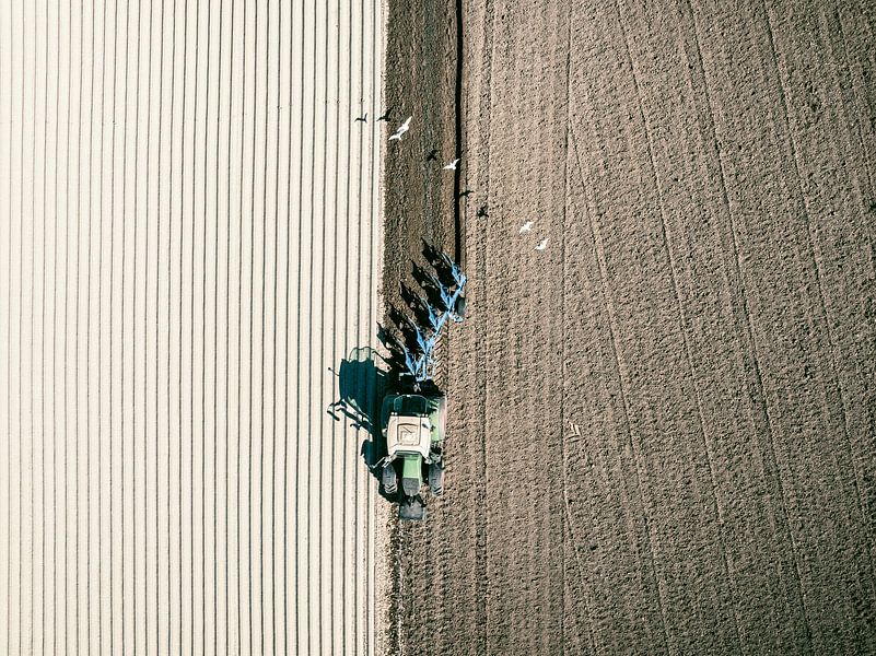 Tractor maakt de grond klaar voor het planten van gewassen van bovenaf gezien van Sjoerd van der Wal Fotografie