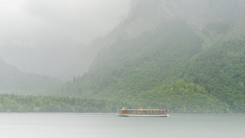 Een harmonieus landschap met een boot in de ochtendmist bij de Königssee in de Berchtesgadener Alpen
