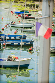 Boats in a small French harbour flying a flag