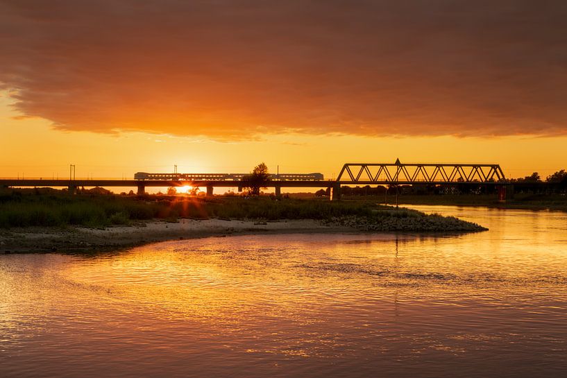 IJssel railway bridge with train near Deventer in golden hour by Karla Leeftink